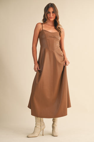 Front angled view of brown Faux Leather Corset Midi Dress with fitted corset top and flowy hem