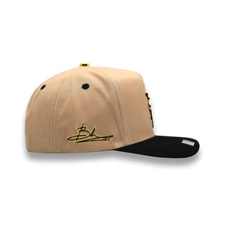 Beige crown with black brim snapback cap, left side view, gold Bk embroidery by Bigg Boss.