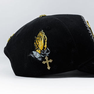Detailed gold praying hands embroidery with jeweled cross on La Guadalupana Snapback.