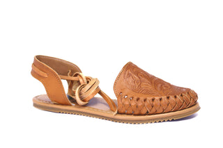 Side view of a honey colored leather lace-up huaraches with a floral imprint face