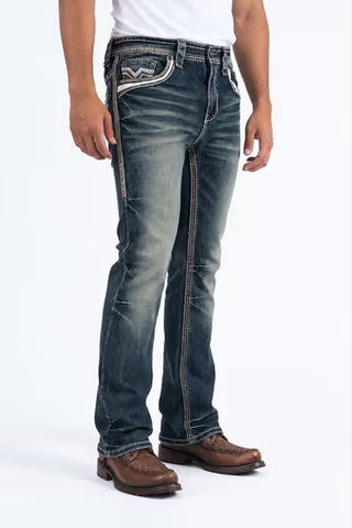 Platini men's Holt slim bootcut jeans in dark blue wash with detailed side seam stitching, faded denim and bootcut leg openings over cowboy boots.