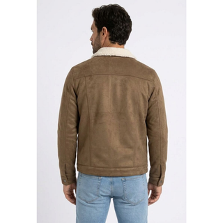 A man viewed from the back wearing a brown faux suede-like jacket with a cream sherpa collar and light blue jeans, set against a plain light gray studio background.