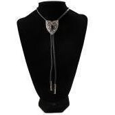 A silver-toned bolo tie necklace with a Arrow-shaped pendant and dangling cords, displayed on a black mannequin bust against a white background.