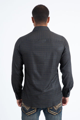 Man wearing a black and multi color long sleeve geometric print button-down shirt paired with jeans, modern men's fashion look