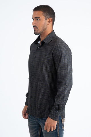 Man wearing a black and multi color long sleeve geometric print button-down shirt paired with jeans, modern men's fashion look- side profile