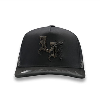 Front view of La Ángel y Demonio Negra Snapback with metallic “LA” emblem