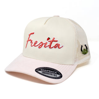 Front view of cream and pink Fresita snapback cap with embroidered red script and small strawberry detail on the letter i and a view of the Mex West Logo on the side