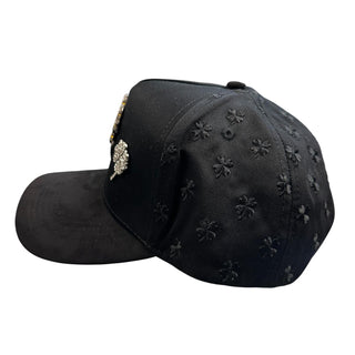 Side view of black snapback hat featuring tonal embroidered clover pattern