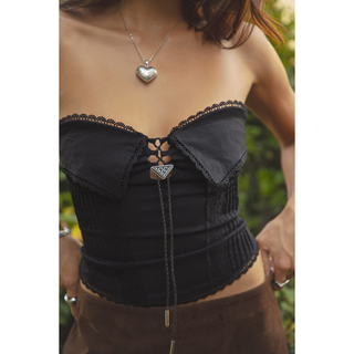 Close-up of Benetti black western top showing scalloped lace trim, foldover collar and triangular bolo tie detail.