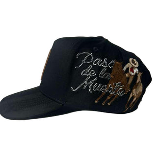 Black cap with 'Paso de la Muerte' text and horse design on a white background