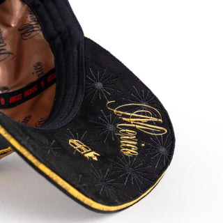 Close-up of black curved brim with gold trim detailing